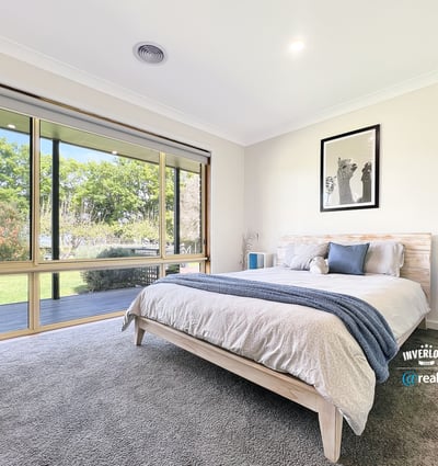 Bright and airy bedroom featuring large windows that invite natural light and offer picturesque garden views.