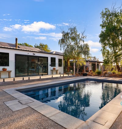 Discover a modern home featuring an inviting outdoor pool and spacious patio, perfect for entertaining.