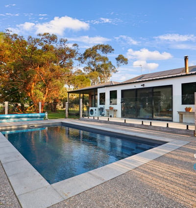 Contemporary home featuring an inviting pool area, surrounded by lush landscaping and ample outdoor space for relaxation.