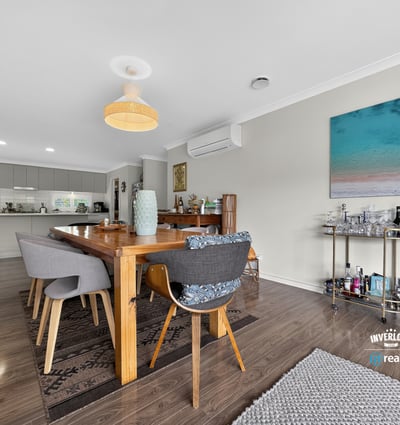 Spacious dining area features modern decor and natural light, perfect for entertaining or family gatherings.