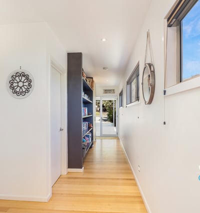 Bright and inviting hallway with seamless flow, showcasing built-in shelves and modern design elements.