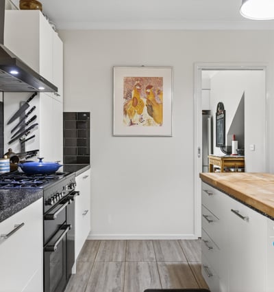 Modern kitchen featuring sleek appliances, ample counter space, and distinct artwork for a vibrant touch.