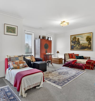 Spacious living area features abundant natural light, unique decor elements, and cozy textiles perfect for gatherings.