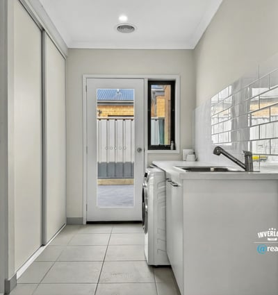 Bright and functional laundry area featuring ample storage and easy access to an outdoor space.