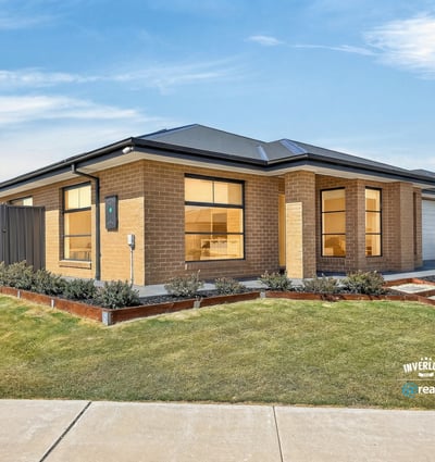Modern home featuring extensive windows, well-kept landscaping, and a spacious driveway in a desirable neighborhood.