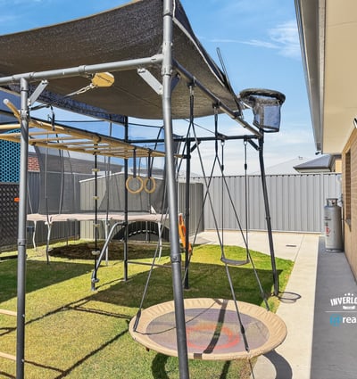 This property features a spacious outdoor area, equipped with a unique play structure and ample lawn space.