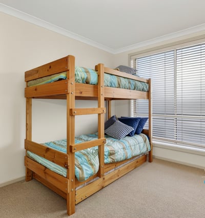 Cozy bedroom featuring a sturdy bunk bed and ample natural light from large windows.