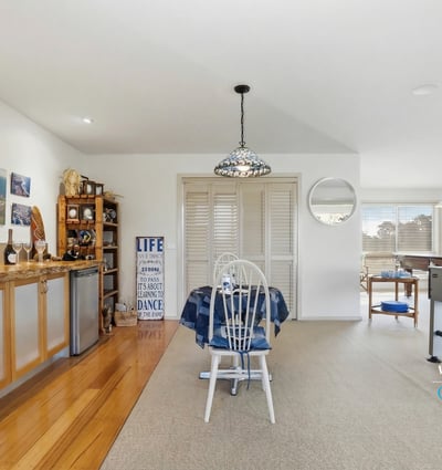 Spacious open-concept living area with natural light, functional bar, and leisure space for entertaining.