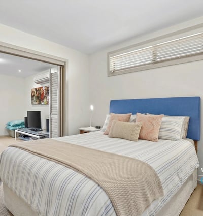 Bright and inviting bedroom with ample natural light, featuring a cozy atmosphere and modern finishes.