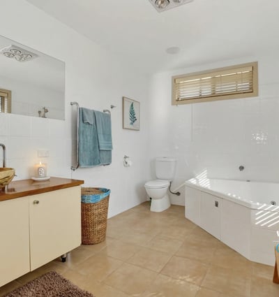 Spacious bathroom featuring a bathtub, modern fixtures, ample light, and thoughtful storage solutions for convenience.
