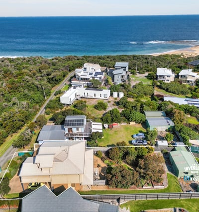 Stunning coastal property with expansive ocean views, surrounded by lush greenery and spacious outdoor areas.