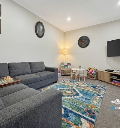 Bright, inviting living area featuring modern furnishings, a playful rug, and ample natural light throughout.