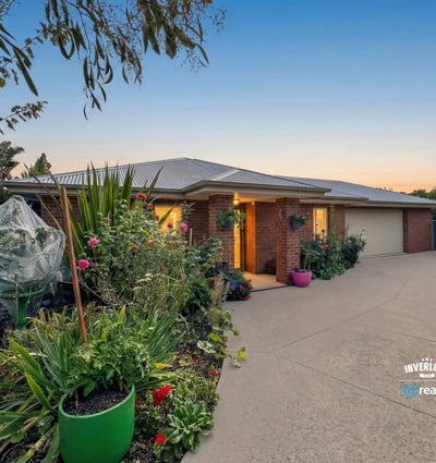 Beautifully landscaped exterior with vibrant garden, inviting entrance, and ample parking space for multiple vehicles.
