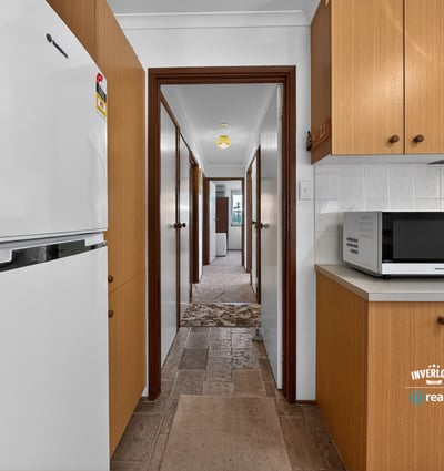 Spacious kitchen leads to ample hallway, offering convenient access to multiple rooms in this inviting home.