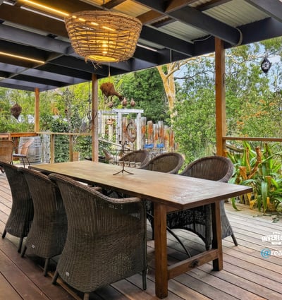 Spacious outdoor deck with ample seating, perfect for entertaining amidst lush greenery and a relaxing atmosphere.