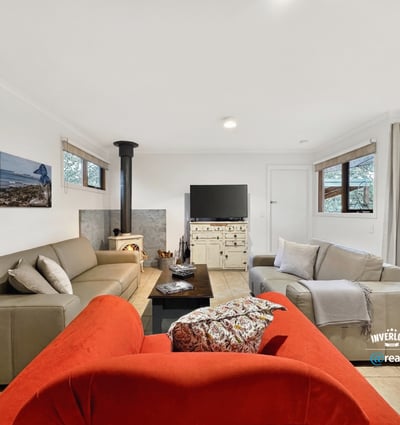 Bright living space featuring natural light, a wood-burning stove, and direct access to outdoor areas.