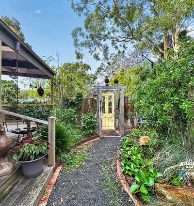 Discover a unique garden pathway leading to a beautifully landscaped outdoor space perfect for relaxation.