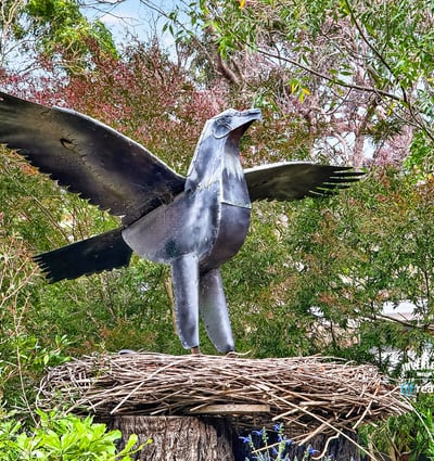 This property features a unique metal sculpture of a bird, adding artistic flair to the lush surroundings.
