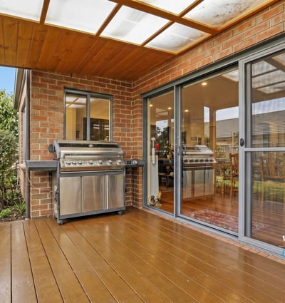 Enjoy outdoor entertaining on this spacious deck, featuring dual BBQs and easy access to the interior.