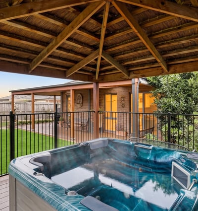 Relax in the inviting hot tub surrounded by lush landscaping and a spacious outdoor retreat.