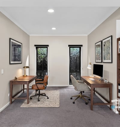 Spacious dual office setup featuring natural light, modern furnishings, and ample shelving for productivity.