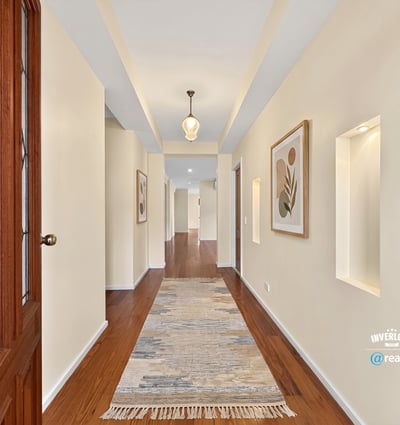 Bright and inviting hallway featuring natural light, modern finishes, and attractive art displays throughout.