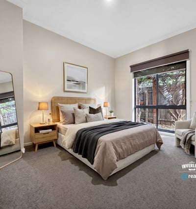 Bright and inviting bedroom featuring large windows, modern decor, and a cozy reading nook for relaxation.