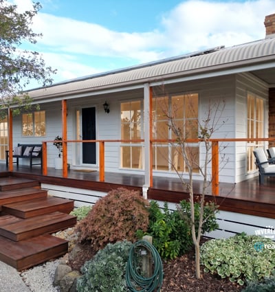 Discover a beautifully designed home featuring a welcoming porch and well-maintained landscaping, perfect for outdoor enjoyment.