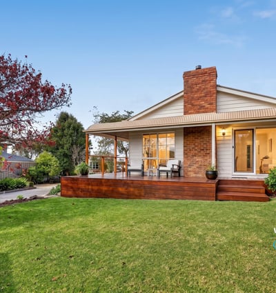 Nestled on a spacious lawn, this home features a welcoming porch and abundant outdoor greenery.