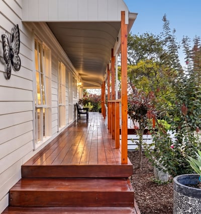 Experience the inviting atmosphere of this well-appointed home with a spacious front porch and lush surroundings.