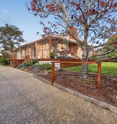 This welcoming home features spacious outdoor areas and a scenic driveway, perfect for family gatherings and relaxation.