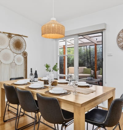 Bright dining area features a spacious table, inviting decor, and views of a cozy outdoor space.