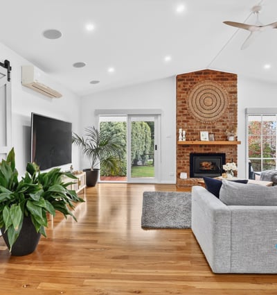 Bright, open living space featuring a distinctive brick fireplace and inviting natural light throughout.