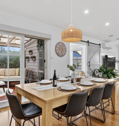 Spacious dining area with natural light, leading to a cozy outdoor retreat for entertaining.