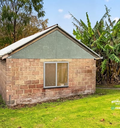 This property offers a unique renovation opportunity amid a spacious backyard surrounded by lush greenery.