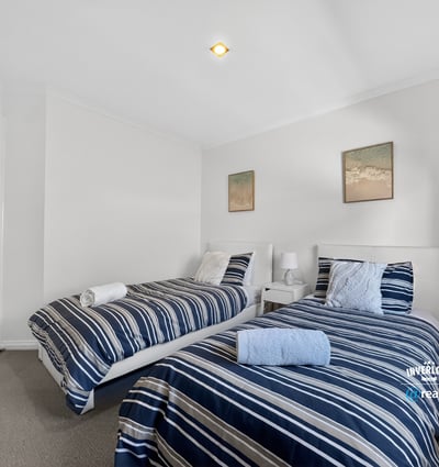 Bright and inviting twin bedroom featuring modern decor and comfortable furnishings for a relaxing stay.