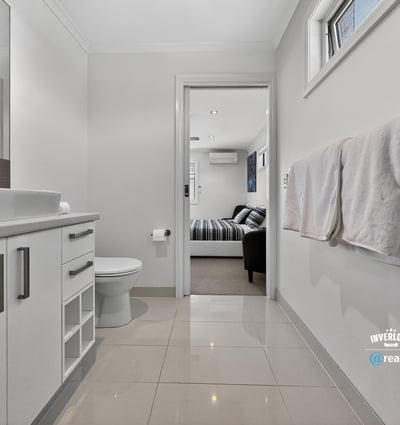Modern bathroom featuring sleek cabinetry and contemporary finishes, seamlessly connecting to a cozy living area.