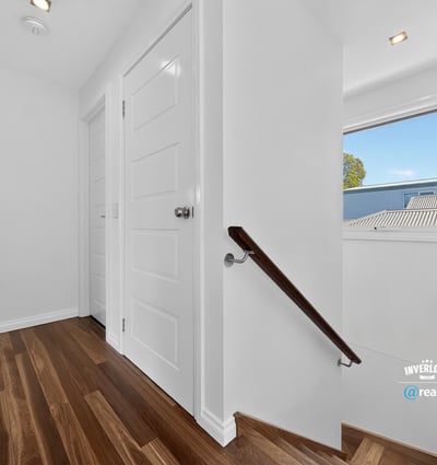 Bright and inviting hallway featuring warm wood flooring and ample natural light from the window.