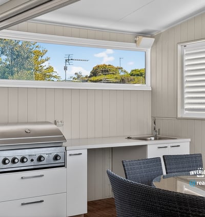 This outdoor entertaining space features a built-in grill and modern kitchen perfect for gatherings.