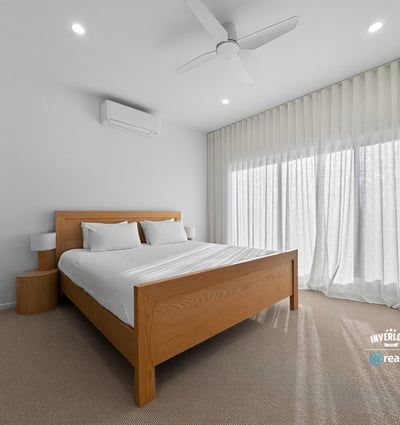Bright and airy bedroom featuring large windows, modern furnishings, and ample natural light.