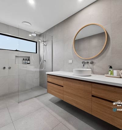 This modern bathroom features a spacious design, sleek finishes, and natural light from a large window.