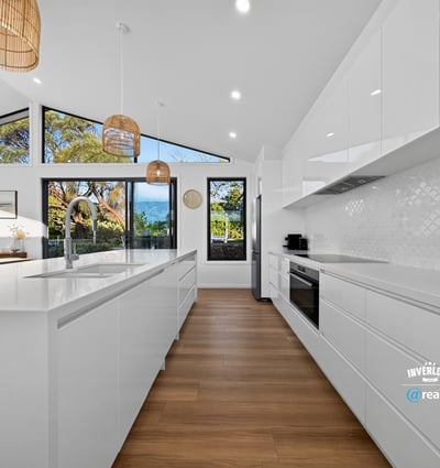 Modern kitchen featuring sleek cabinetry, ample natural light, and scenic views, perfect for culinary enthusiasts.