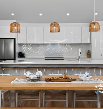 Modern open-plan kitchen featuring sleek cabinetry, a spacious dining area, and unique pendant lighting.