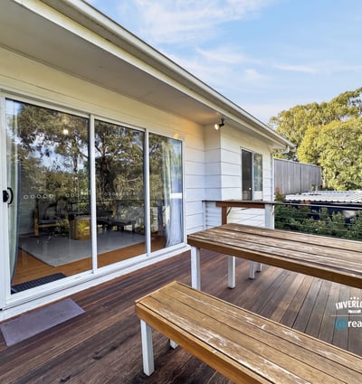 Bright outdoor space featuring a spacious deck, perfect for gatherings and enjoying the surrounding greenery.