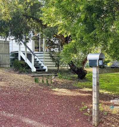This property features a spacious yard with mature trees and a welcoming front porch, ideal for gatherings.