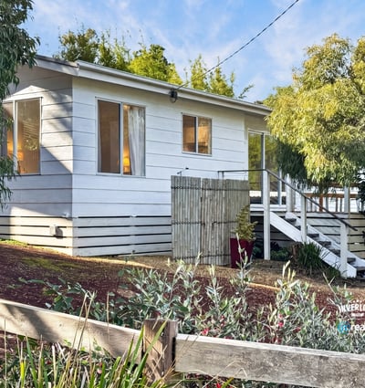 This inviting home features ample windows, a spacious outdoor area, and a welcoming front porch.