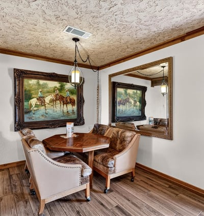 Cozy dining nook features natural light, unique artwork, and a welcoming atmosphere for intimate gatherings.