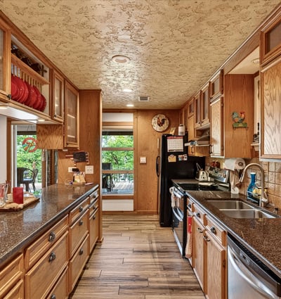 Spacious kitchen featuring ample cabinetry, granite countertops, and large windows that invite natural light.