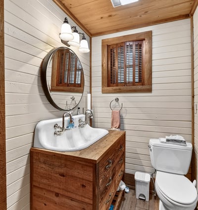 Cozy bathroom featuring a double sink vanity, natural wood accents, and soft lighting for a warm ambiance.