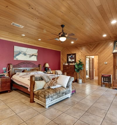 Spacious master bedroom featuring warm wood accents and ample natural light, perfect for relaxation and retreat.